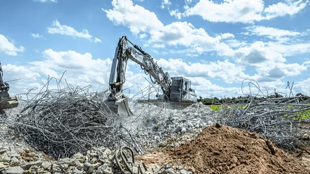 Bagger auf einer Rückbaufläche mit Beton und Bewehrungsstahl