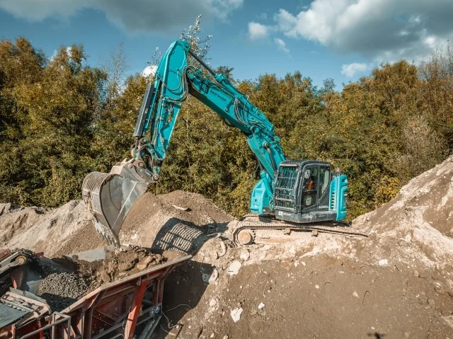 Bagger beim Beschicken einer mobilen Aufbereitungsanlage